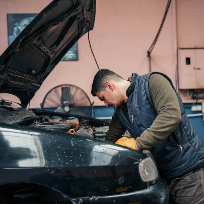 KFZ-Mechatroniker bei der Arbeit an einem Fahrzeug in der Werkstatt