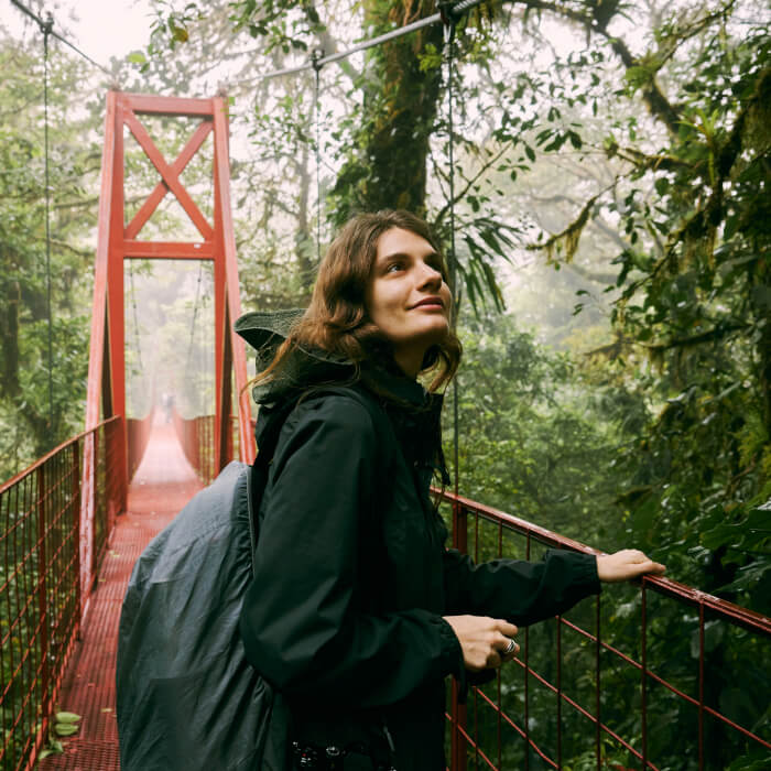 Eine Touristen geht nach der Empfehlung von einem Touristikberater über eine Holzhängebrücke.