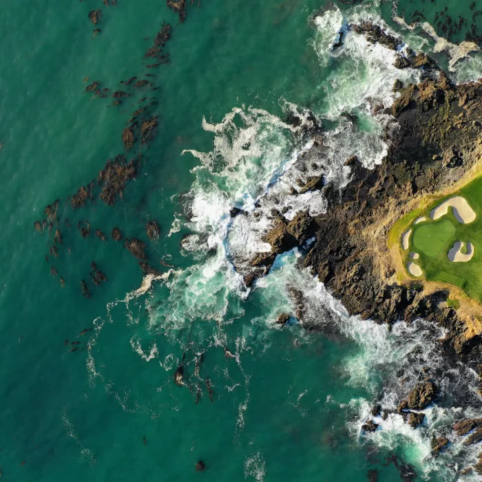 Golfplatz am der Küste, auf dem Golftrainer arbeiten, mit einer Drohne von oben fotografiert