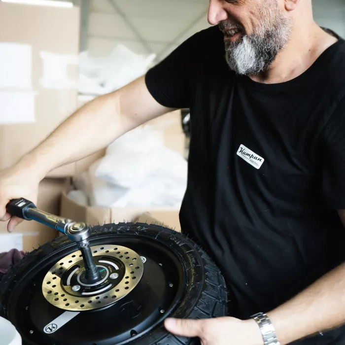 Ein Produktionsmitarbeiter sorgt dafür, dass kein Reifen jemals an unseren Elektrorollern versagen wird. 💚